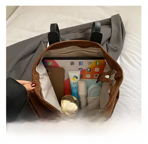 Vista macro dell'interno spazioso con una tasca con zip in questa borsa tote marrone di classe
