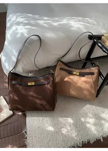 Dettaglio delle borse tote in camoscio retrò con cinturini in pelle e chiusure dorate