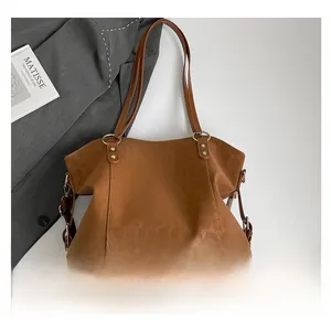 Detail of brown leopard embossed texture and gold metal ring hardware on the tote bag