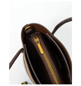Detailed close-up of smooth gold zipper hardware and interior lining of the bucket bag