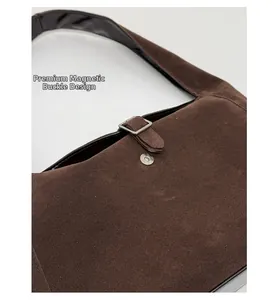 Detail of the high-quality magnetic closure and stitching on dark brown suede handbag
