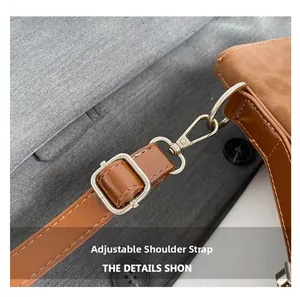 Detail of adjustable brown leather shoulder strap with durable silver metal hardware