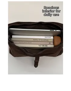 Top view of spacious brown suede hobo bag interior holding a laptop and books