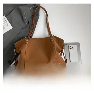 Detail of caramel tote bag showing large capacity with tablet and phone for scale