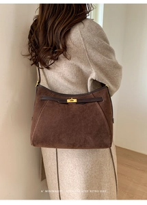 Primo piano di una borsa tote in pelle scamosciata marrone scuro con chiusura a scatto dorata