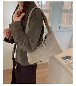 Chic khaki faux suede shoulder bag shown on model in a minimalist interior setting