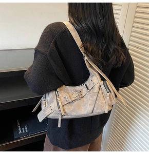 Vue détaillée du sac à bandoulière beige vintage avec fermetures éclair et œillets