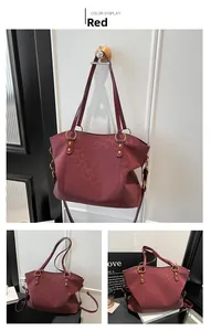 Macro view of burgundy tote bag with leopard embossing and gold metal hardware rings