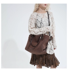 Detail of dark brown tote bag featuring subtle leopard print texture and gold hardware