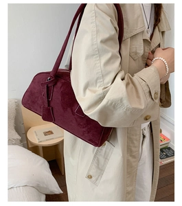 Deep red suede bowling bag styled with a trench coat for a minimalist daily look