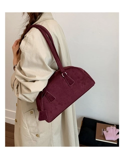 Detail of burgundy suede shoulder bag showing matte texture and silver hardware rings