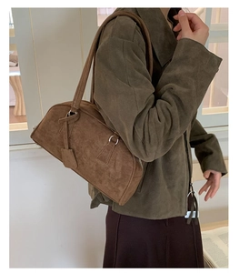 Detail of vintage brown suede boston bag showing soft texture and shoulder strap