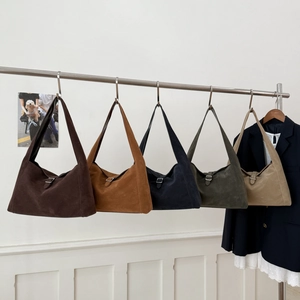 Minimalist large suede tote bags in five colors hanging on a rack for elegant commuting