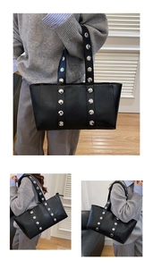 Detail of black leather tote bag with silver studs and adjustable shoulder straps