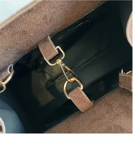 Detail of durable gold metal swivel hook inside large brown suede tote bag