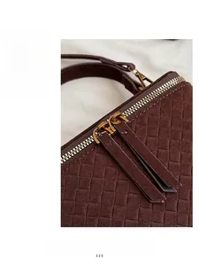 Detail of brown woven leather texture with gold double zippers and long pulls