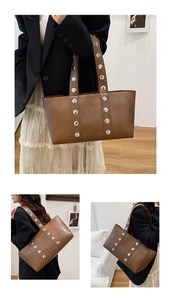 Detail of a brown faux leather tote bag featuring stylish silver metal rivet decorations
