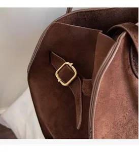 Detail shot of the vintage brown suede tote bag with its elegant golden metal square buckle