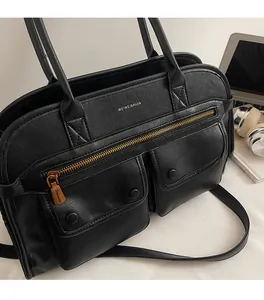 Detail of black faux leather tote bag with dual magnetic pockets and gold zipper closure