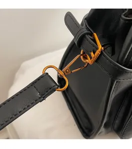 Detail shot of vintage bronze metal buckle and buckle straps on a black tote bag