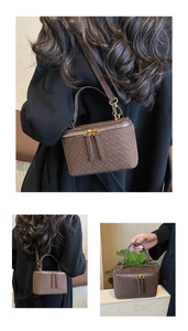 Detail of woven texture on dark brown mini box bag with gold double metal zippers