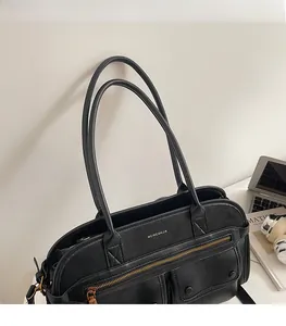 Detail view of retro black PU leather tote bag with dual straps and metal zipper pockets