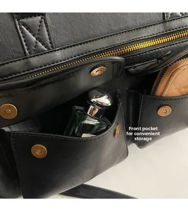 Macro shot of front pockets with metal snaps and zip on black leather tote bag