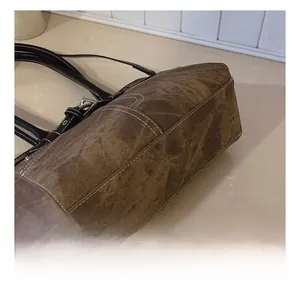 Detail showing white contrast stitching on brown vintage shoulder bag with silver buckle