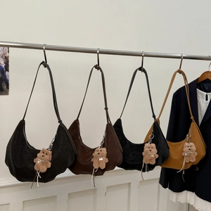 Detail view of colorful hobo bags with velvet texture and cute plush bear charms