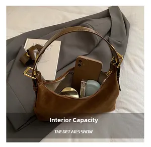 Internal capacity of the brown suede crescent bag with gold hardware and accessories