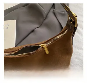 Detail of premium brown suede bag with gold zipper and smooth matte textured finish