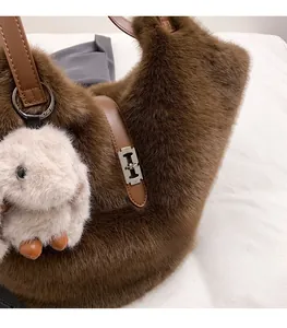 Detail of plush brown faux fur tote bag featuring silver H-buckle and rabbit charm