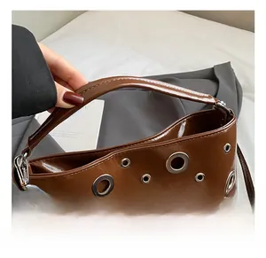 Détails des œillets métalliques et coutures de la poignée du sac fourre-tout brun