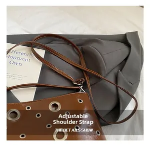 Détail de la sangle réglable sur le sac seau marron rétro punk avec œillets métalliques