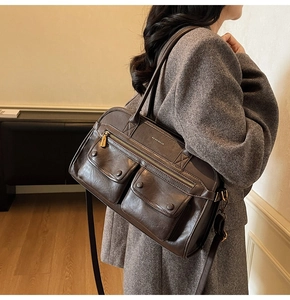 Detailed side view of a large vintage brown PU leather tote bag with exterior snap pockets