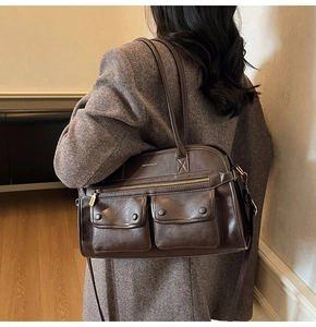 Detail view of deep brown vintage faux leather handbag with multi-pocket design on side profile