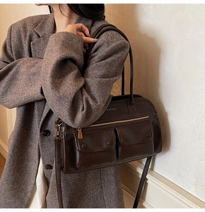 Detail of dark brown vintage faux leather tote bag with front flap pockets and hardware