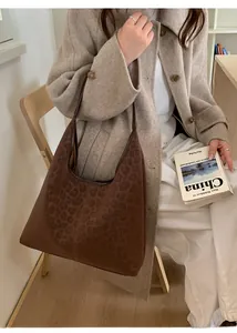 Détail d'un grand sac cabas léopard en daim porté à l'épaule pour un style vintage chic