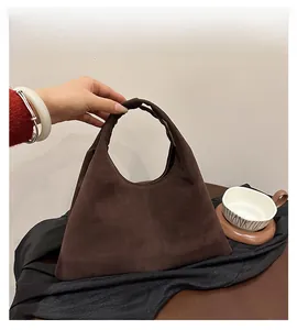 Detail of vintage dark brown suede tote bag with knotted handle and triangular silhouette