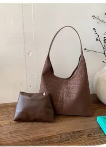 Détail du cabas vintage léopard avec pochette sur une surface en bois rustique