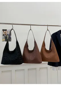 Vue détaillée de trois sacs cabas léopard en noir, marron foncé et marron clair