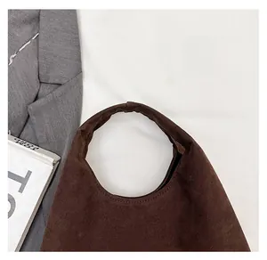 Detail of retro coffee brown tote bag handle with fine stitching on matte suede material