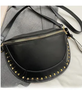Detail of black faux leather crescent saddle bag featuring gold stud trim and metallic zipper