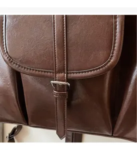 Gros plan détaillé sur le cuir brillant marron foncé avec boucle vintage en argent