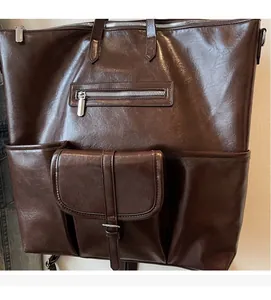 Détail du sac bandoulière en similicuir marron avec plusieurs poches zippées