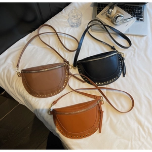 Detailed macro view of vintage half-moon crossbody bags with gold stud embellishments