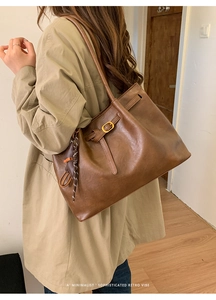 Close-up of leopard print shoulder bag with gold buckle and woven strap details