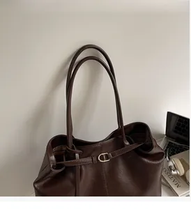 Detail of dark brown vintage faux leather tote with sleek straps and metal buckle accent