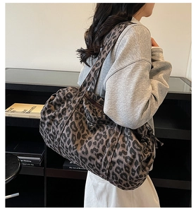 Detail shot of large leopard print tote bag featuring metallic magnetic closure and wide straps