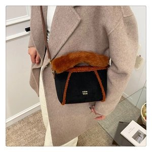 Dettaglio della finitura in ecopelliccia marrone su borsa in scamosciato nero con logo